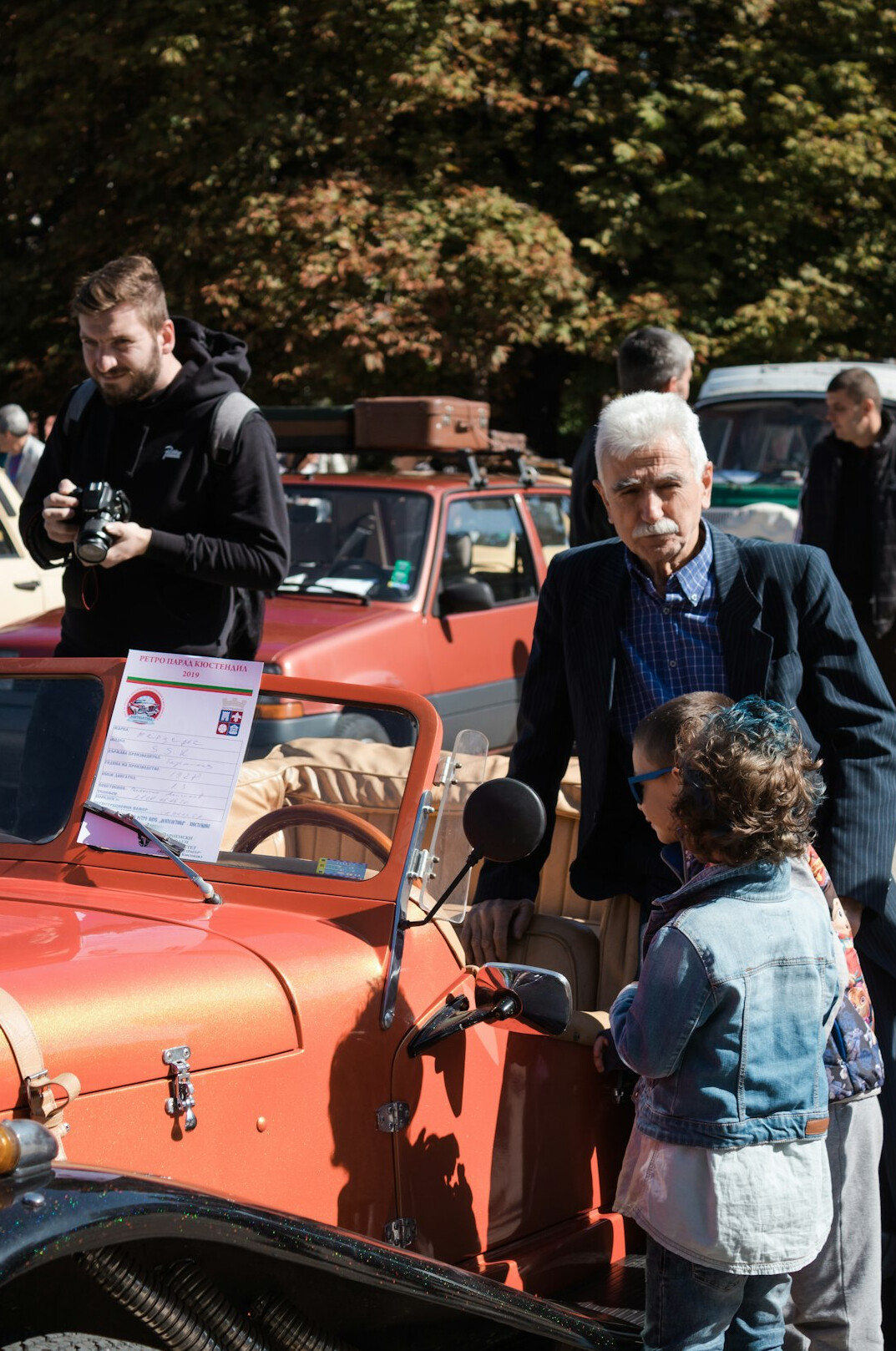 Small group walking through a private classic car collection during a guided tour