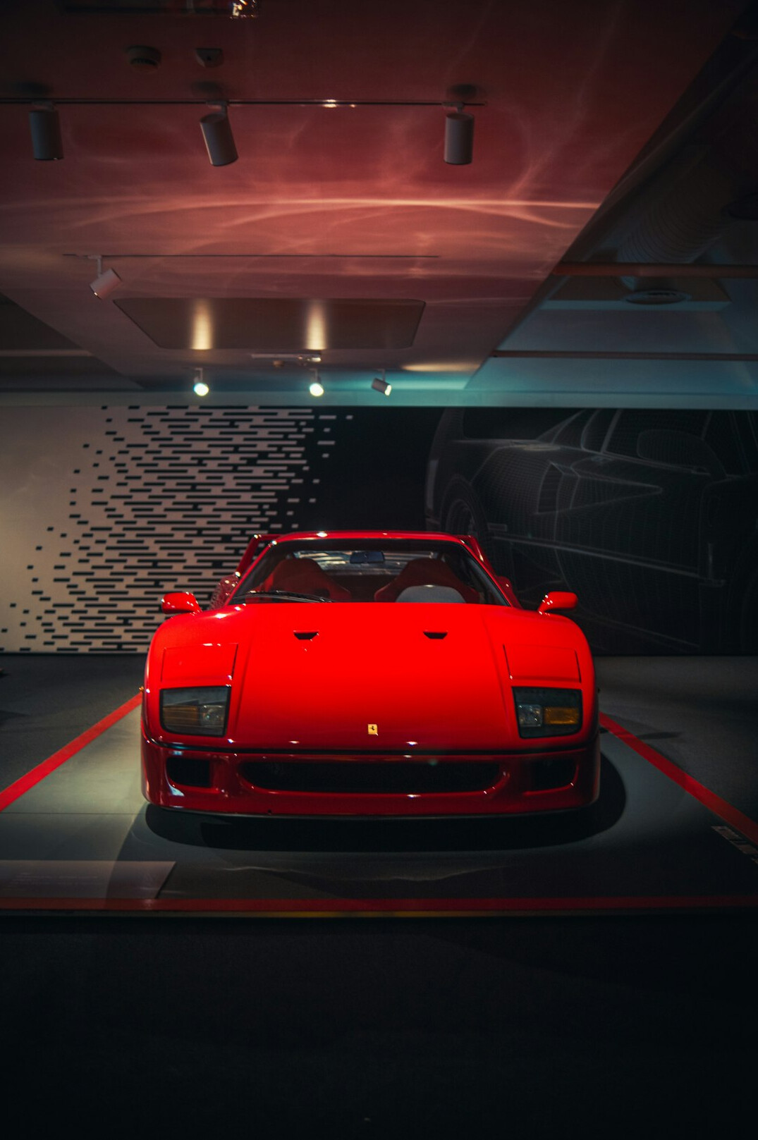 Vintage Ferrari displayed on a rotating pedestal at an auction preview