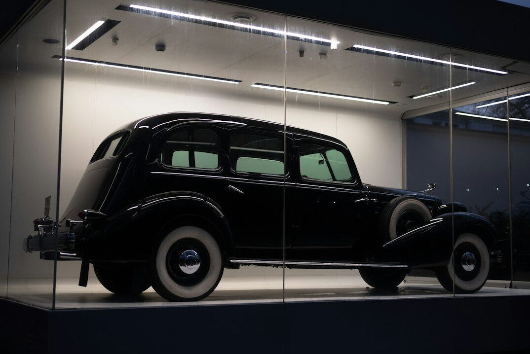 Dark showroom with a single spotlighted vintage automobile set up for a 360 degree virtual view